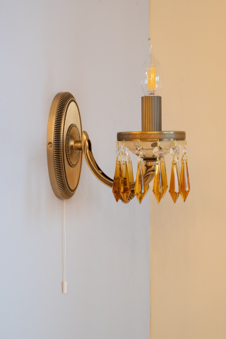 Lampada da muro classica in fusione di ottone, color Bronzo Arte. Vetro molato colore crema. Prisma in cristallo color Topazio. Prodotto in Italia. Codice A.5681/1