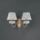 2 light brass and painted porcelain wall sconce with lamp shade. The lampshade fabric shown in the product photo is no longer available. The lampshades will be shipped with the new fabric as in the second photo.