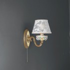 Wandlampe aus goldenen Messing und bemalten Porzellan mit Lampenschirm. Der auf dem Produktfoto abgebildete Lampenschirmstoff ist nicht mehr verfügbar. Die Lampenschirme werden wie auf dem zweiten Foto mit dem neuen Stoff versendet.